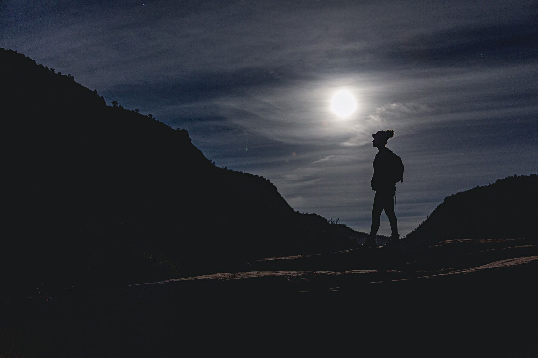 Lydia on top of Angels Landing under a full moon in Zion National Park, Utah