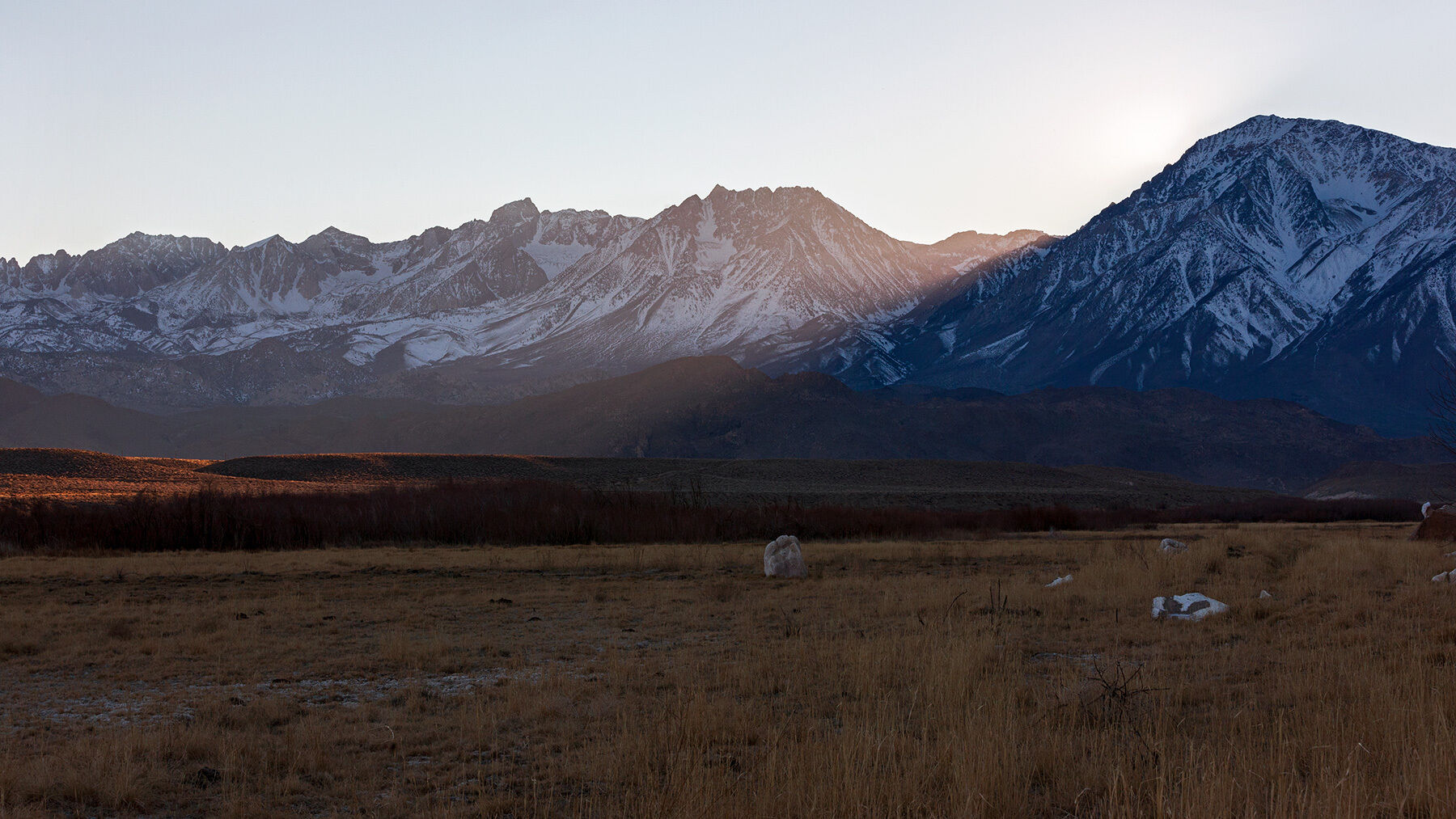 Sun streaks over the side of the Sierras in Bishop, California