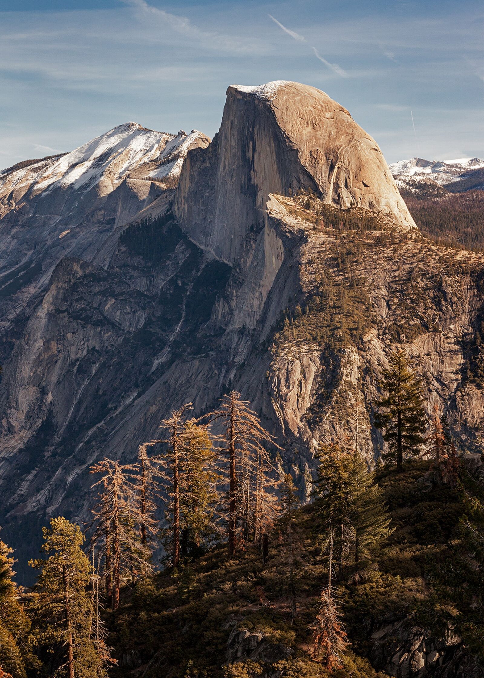 A profile landscape view of Half Dome with snow on top in Yosemite National Park, California