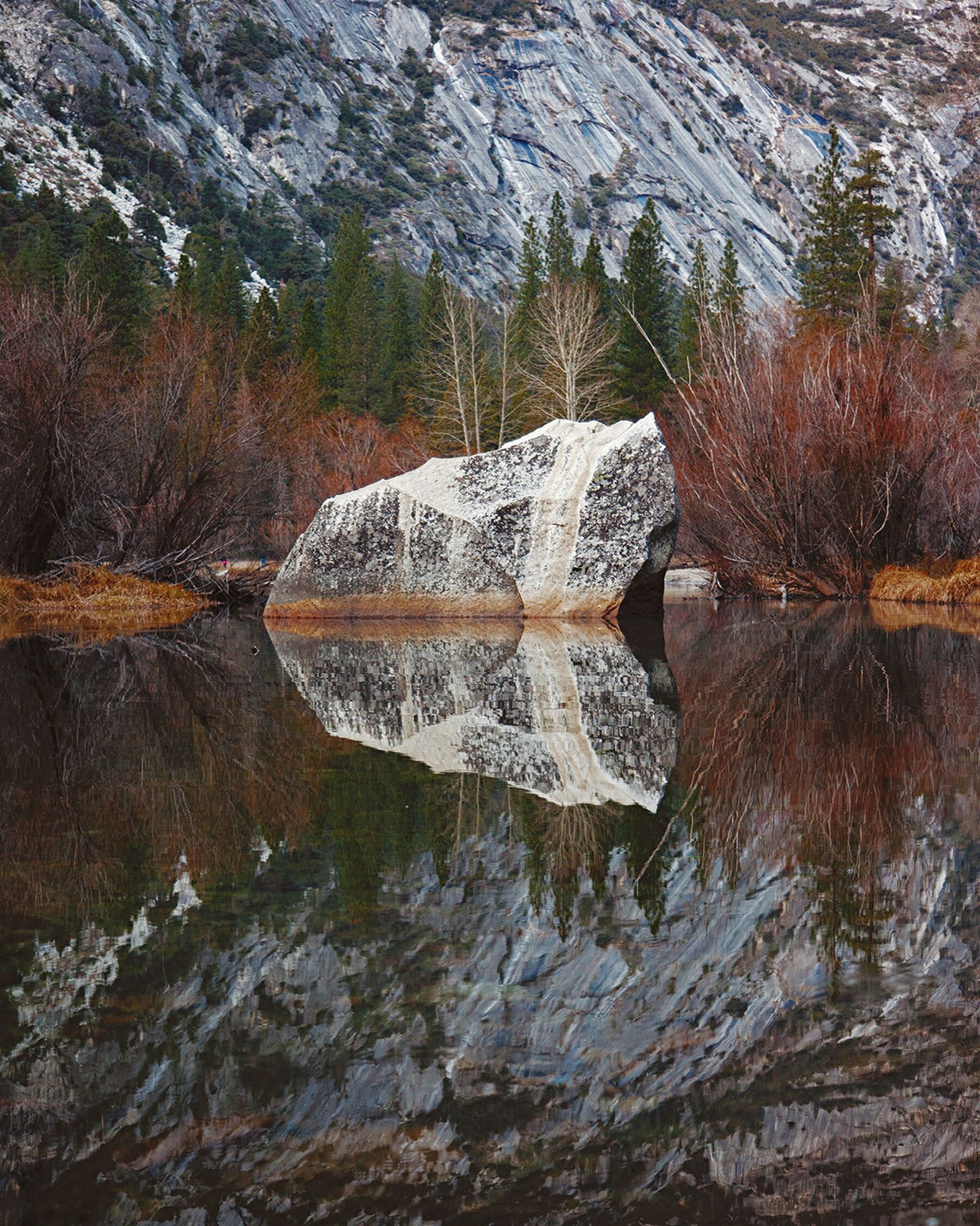 A boulder reflected in the glassy waters of Mirror Lake in Yosemite National Park, California