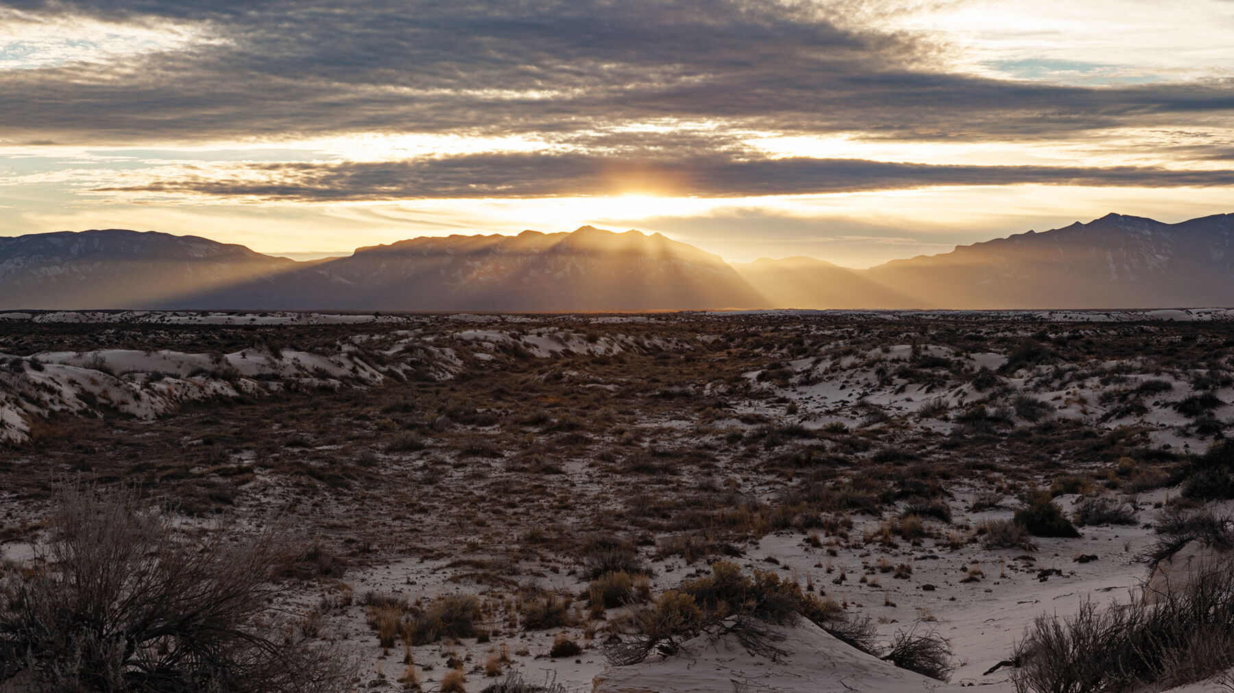 The sun setting over mountains in White Sands National Monument, New Mexico