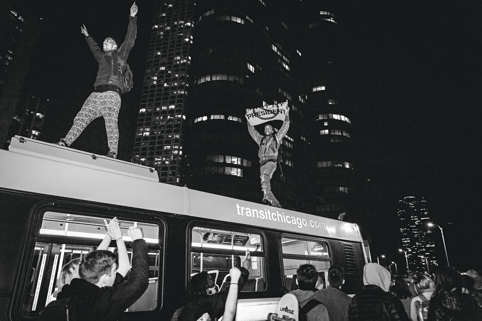 Demonstrators standing on top of a CTA Bus in Chicago protesting the election of Donald Trump