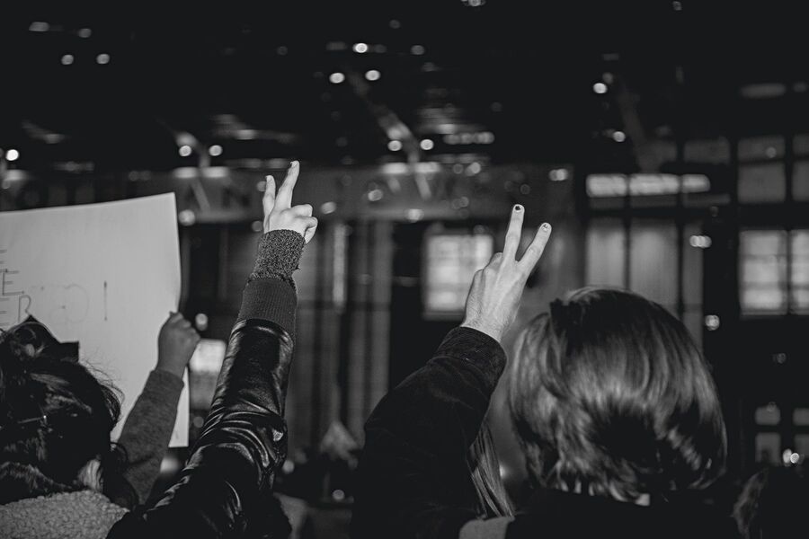 People raising peace signs in the air at a demonstration protesting the election of Donald Trump in 2016