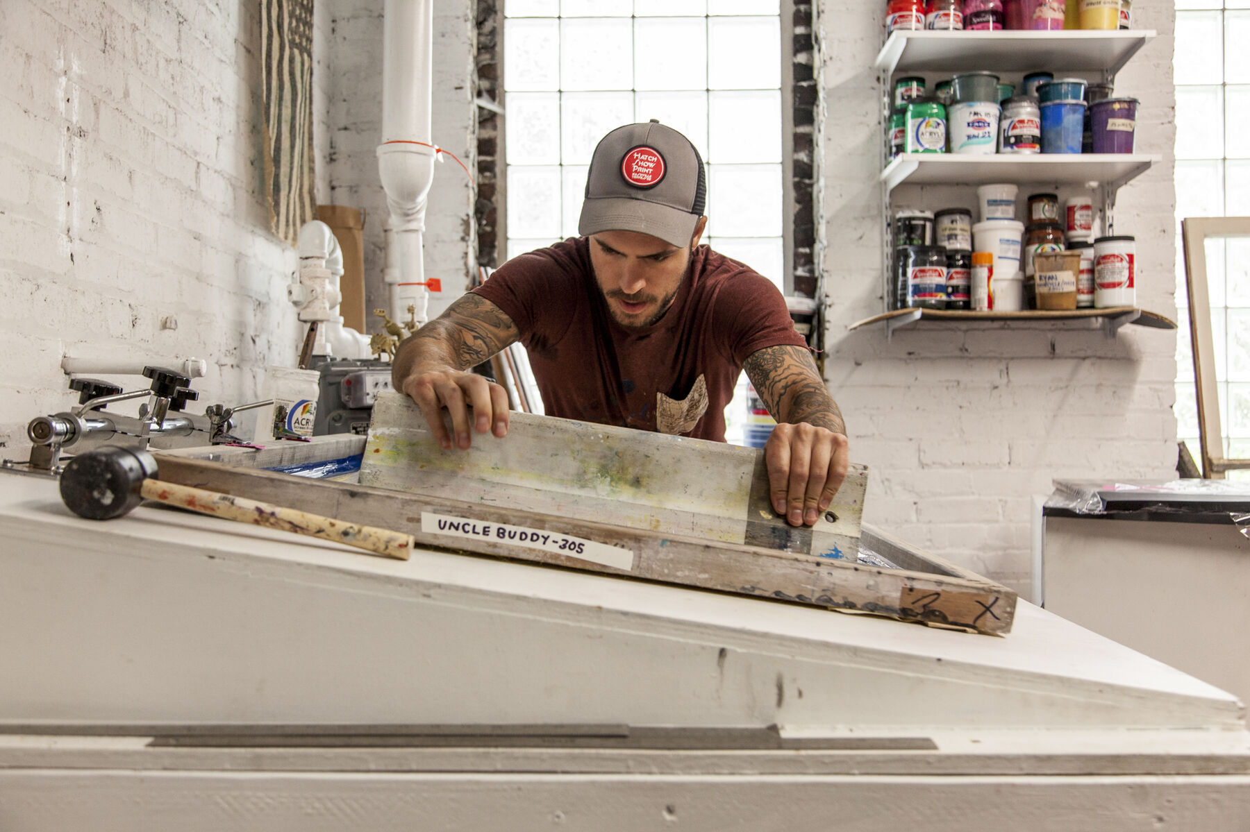 Tyler pulling ink over a screen at Ghost Press screen printing studio