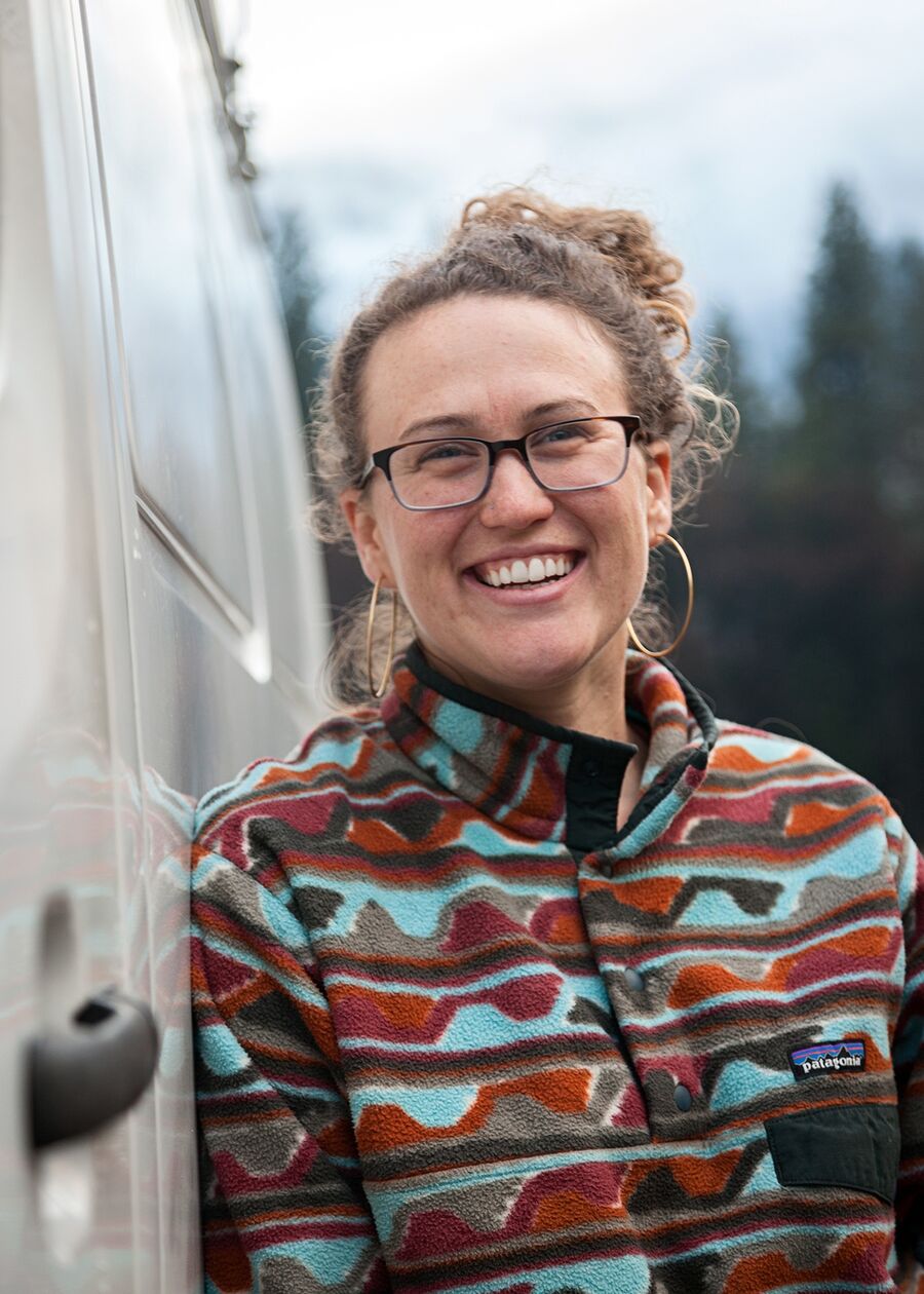 Lydia smiling leaning against van in Yosemite National Park, California