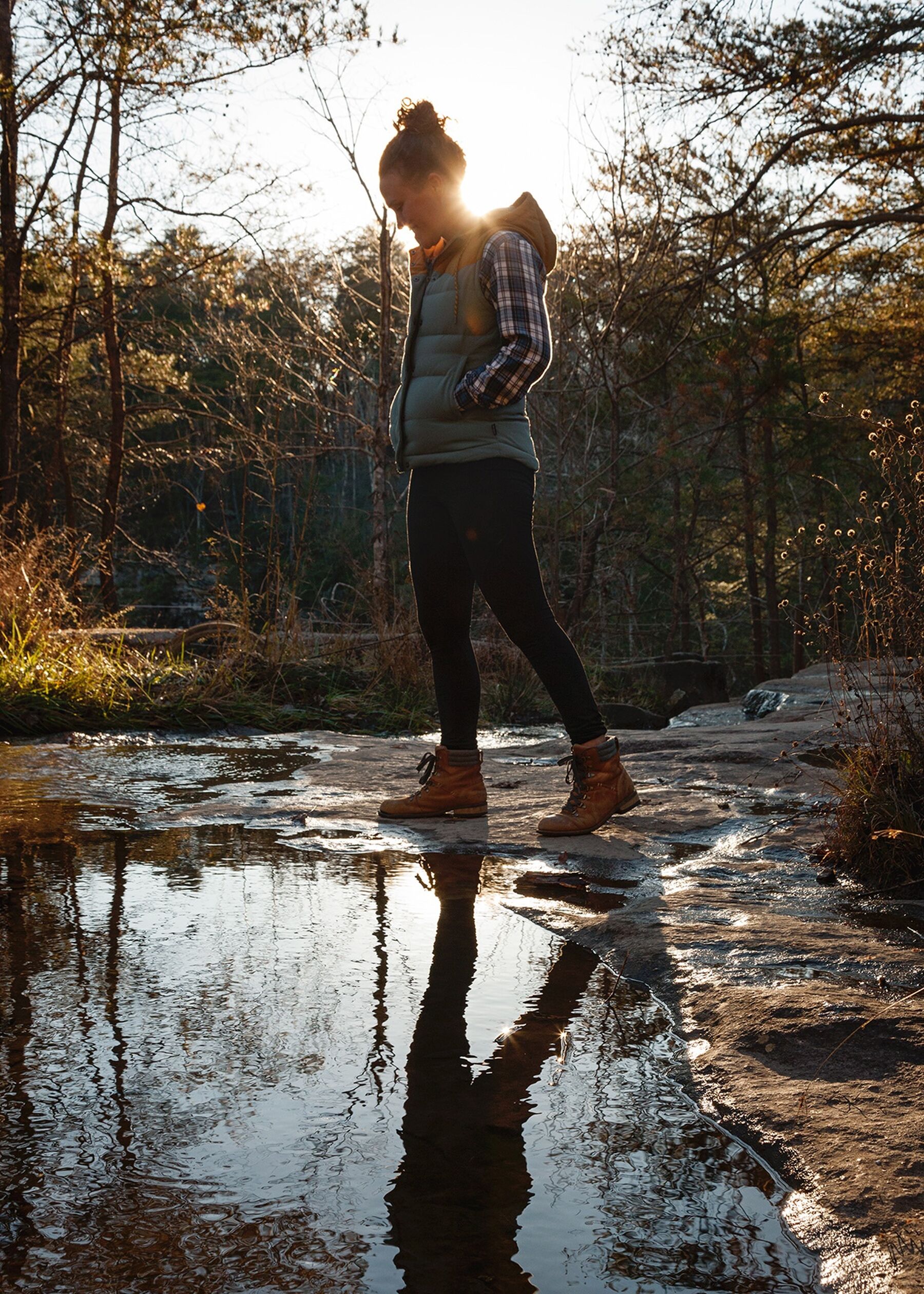 Lydia hiking with her reflection in a puddle at Foster Falls in Tennessee