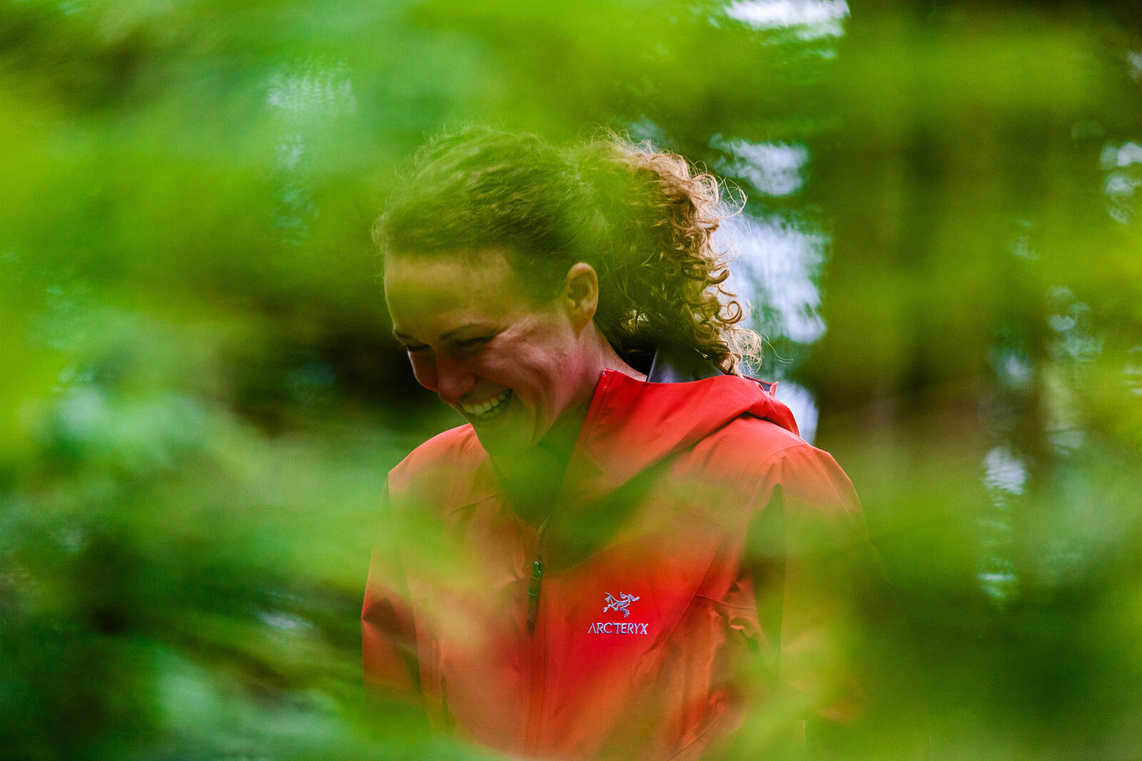 Lydia laughing through green leaves