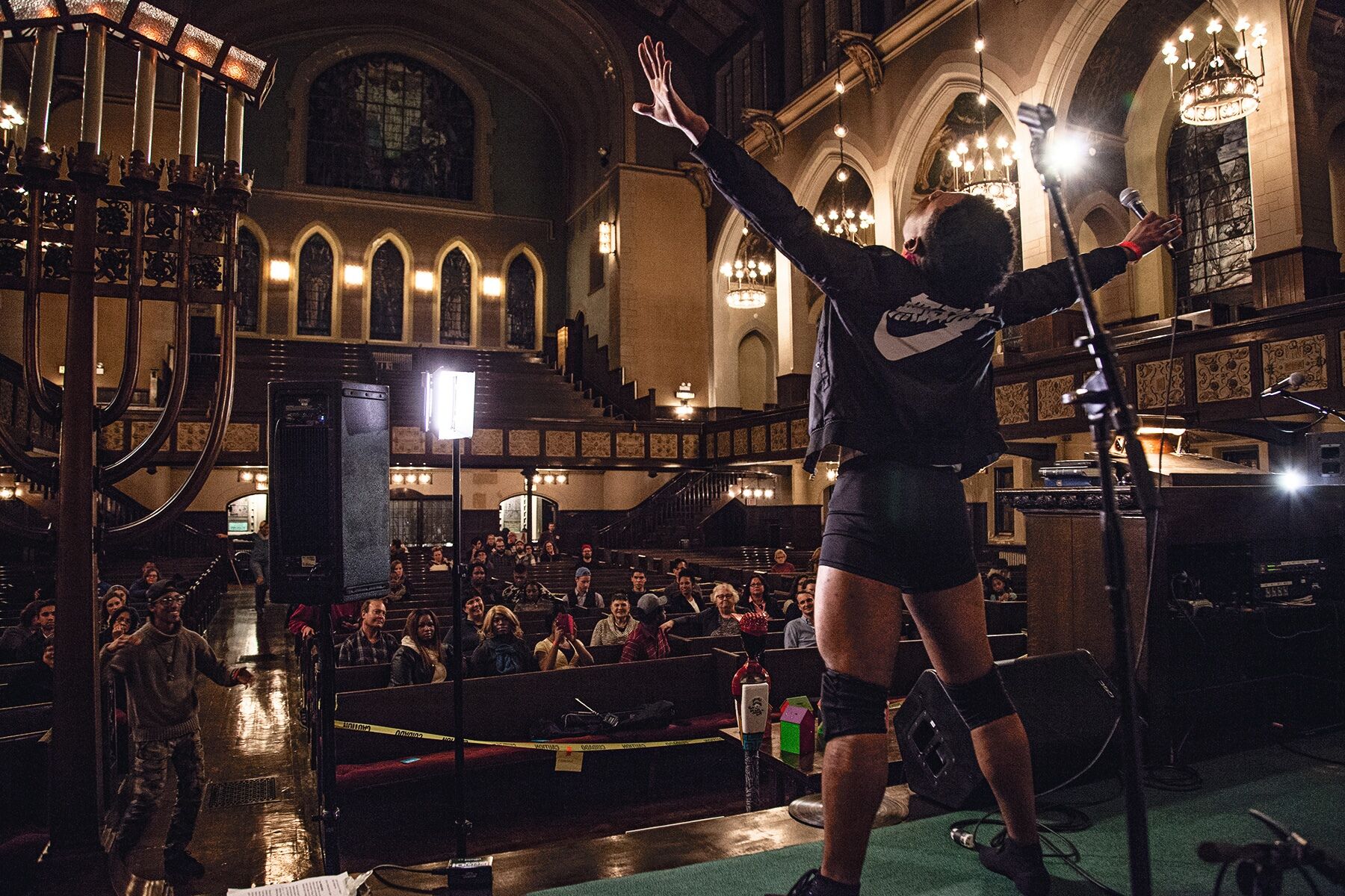 Sonny Apollo performs on stage in a church for Sleep Out Chicago