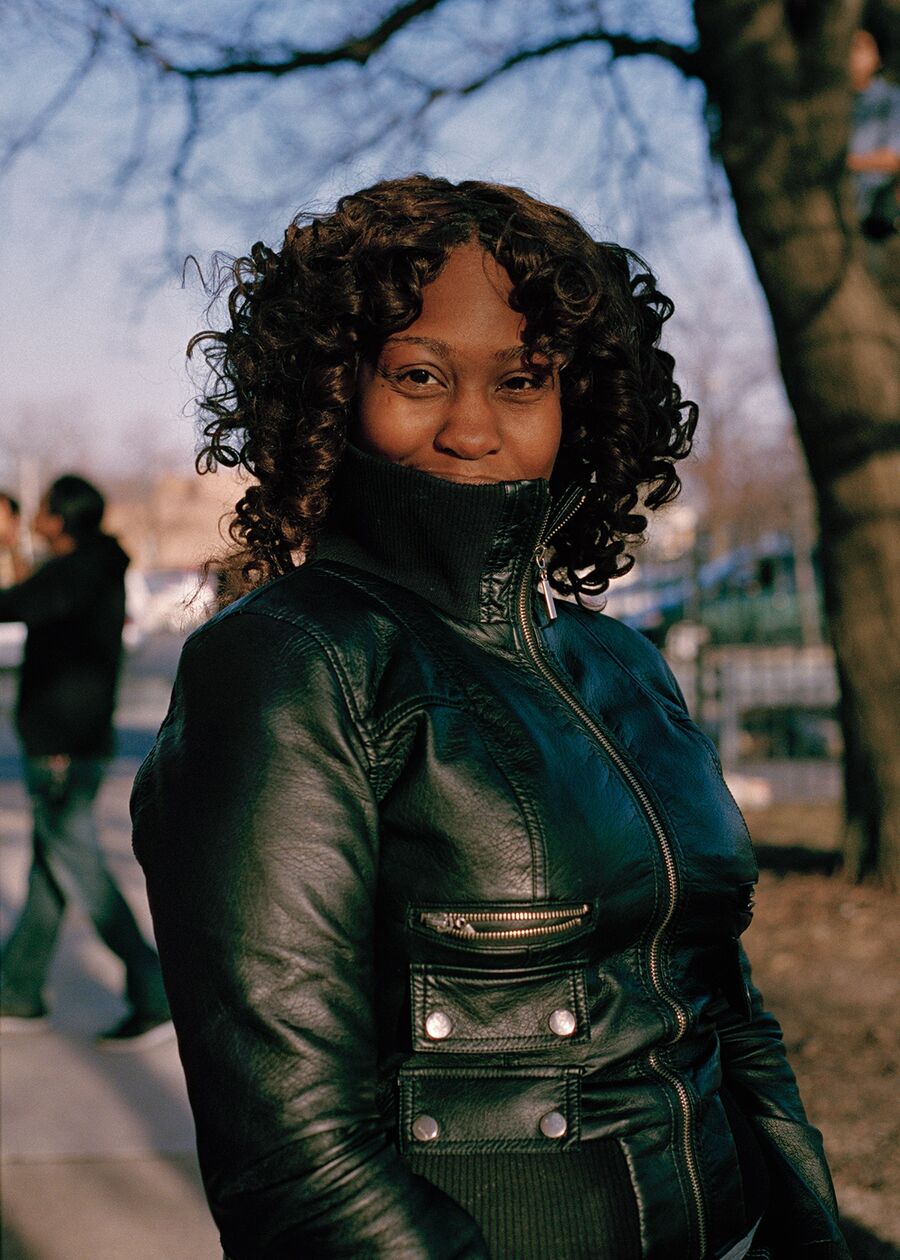 Stephany posing with the collar of her leather jacket over her mouth