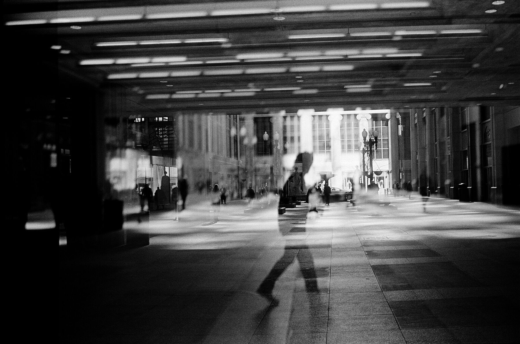 A double exposure of a man walking under the Board of Trade building in Chicago